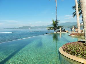 a swimming pool with a view of the ocean at Sea Breeze Candidasa in Candidasa