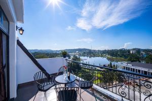 a balcony with a table and chairs and a view of a river at Win Hotel Đà Lạt in Da Lat