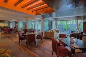 a restaurant with tables and chairs and a living room at Oakwood Residence Naylor Road Pune in Pune