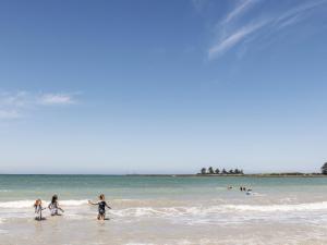 three children playing in the water at the beach at Bella On Victoria in Port Fairy