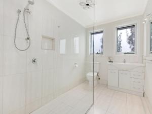 Un baño blanco con ducha y WC. en East Beach House, en Port Fairy 12 fotos más