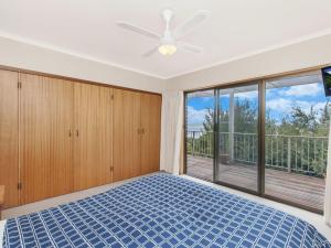 Un dormitorio con una cama y una ventana grande. en East Beach House, en Port Fairy