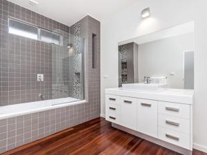 a bathroom with a tub and a sink and a mirror at Escape 2 Brophy in Port Fairy