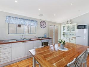 a kitchen with a wooden table and a refrigerator at Ginabella in Port Fairy