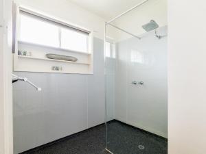 um chuveiro com uma porta de vidro na casa de banho em Hakuna Matata em Port Fairy