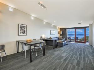 a living room with a table and chairs and the ocean at Hearns Beachside Villa 2 in Port Fairy