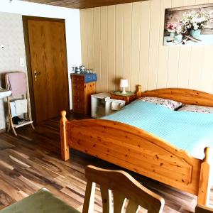 1 dormitorio con cama de madera y silla de madera en Wagnermoosgut en Bad Ischl