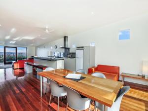 a kitchen and dining room with a wooden table and chairs at Hearns Beachside Villa 4 in Port Fairy