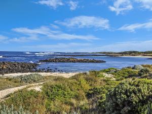 a view of the ocean with rocks in the water at Hearns Beachside Villa 2 in Port Fairy +1 photo