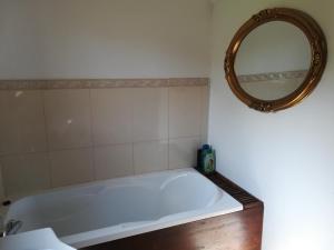 y baño con bañera blanca y espejo. en Casa Zara, en Bran 31 fotos más