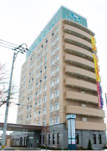 un gran edificio con un cartel en el costado en Hotel Route-Inn Morioka Minami Inter, en Morioka