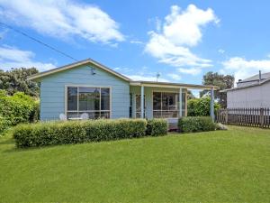 a small blue house with a lawn in front of it at Killead On East in Port Fairy