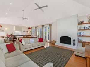 sala de estar con sofá y chimenea en Kinsale Cottage, en Port Fairy