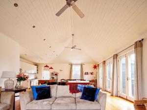 sala de estar con sofá y ventilador de techo en Kinsale Cottage, en Port Fairy