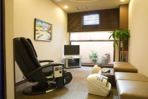 a living room with a chair and a couch at Hotel Route-Inn Morioka Minami Inter in Morioka