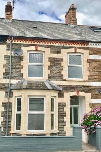 Cette grande maison en briques possède des fenêtres donnant sur une rue. dans l'établissement Railway Street by Switchback Stays, à Cardiff