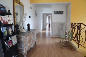 a living room with a wooden floor and a hallway at B&B La Maison de L'Aubette in Magny-en-Vexin