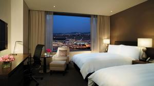 a hotel room with two beds and a window at LOTTE City Hotel Gimpo Airport in Seoul