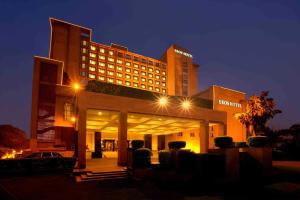 a hotel building with a parking lot at night at Eros Hotel New Delhi, Nehru Place in New Delhi