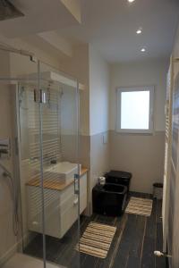 ein Bad mit einer Glasdusche und einem Waschbecken in der Unterkunft Nest in the city in Triest
