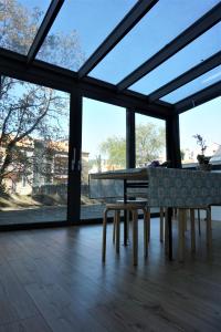 ein Esszimmer mit einem Tisch und einigen Fenstern in der Unterkunft Nest in the city in Triest