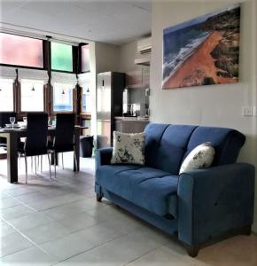 a blue couch in a living room with a kitchen at 85 Palma Living in Victoria