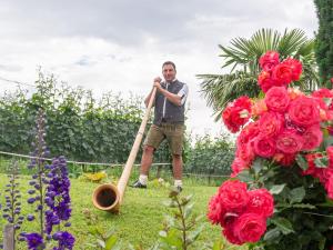 a man standing in a garden with a baseball bat at Obst- und Ferienhof Gomeringer in Immenstaad am Bodensee