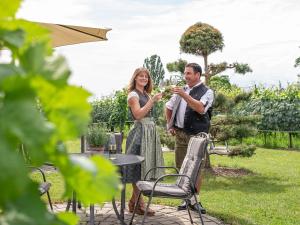 a man and woman standing in a garden drinking wine at Obst- und Ferienhof Gomeringer in Immenstaad am Bodensee
