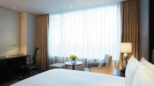 a hotel room with a bed and a desk and a window at LOTTE City Hotel Gimpo Airport in Seoul