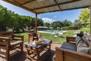 a patio with a table and chairs and a pool at Villa Lorena in Morro dʼAlba