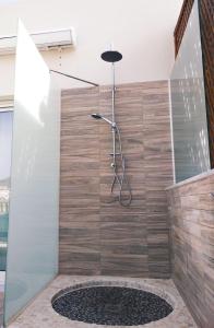 a shower with a wooden wall and a shower head at 4nudos playa in San José