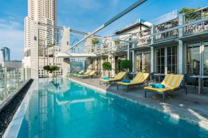 a swimming pool with chairs and a building at Akara Hotel in Bangkok +132 photos