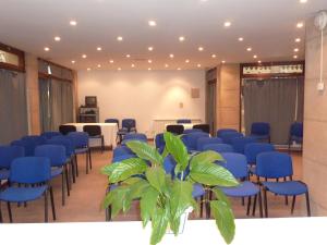 a meeting room with blue chairs and a potted plant at Hotel Alameda in Zarautz