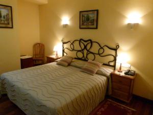 a bedroom with a large bed with two tables and two lamps at Hotel Alameda in Zarautz