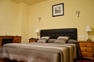 a bedroom with a large bed with a black headboard at Hotel Alameda in Zarautz