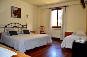 a bedroom with two beds and a window at Hotel Alameda in Zarautz