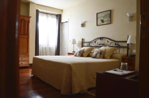 a bedroom with a large bed and a window at Hotel Alameda in Zarautz