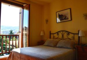 a bedroom with a bed and a large window at Hotel Alameda in Zarautz