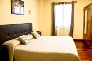 a bedroom with a bed with pillows and a window at Hotel Alameda in Zarautz