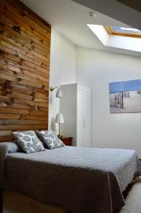 a bedroom with a bed and a wooden wall at Hotel Alameda in Zarautz