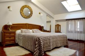 a bedroom with a bed and a mirror on the wall at Hotel Alameda in Zarautz