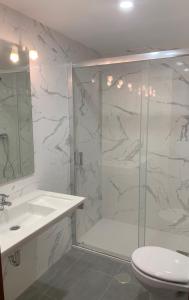 a bathroom with a shower and a toilet and a sink at Hotel Alameda in Zarautz