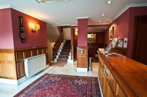 a lobby with red walls and stairs with a rug at Hotel Alameda in Zarautz