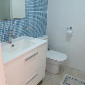 uma casa de banho com um lavatório branco e um WC. em Little Venice Apartment in Puerto de Mogan em Puerto de Mogán