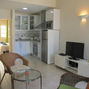 uma cozinha com uma mesa e uma televisão num quarto em Little Venice Apartment in Puerto de Mogan em Puerto de Mogán