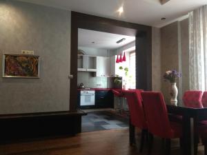 Apartment on Dubenskaya street في روفنو: مطبخ وغرفة طعام مع طاولة وكراسي حمراء