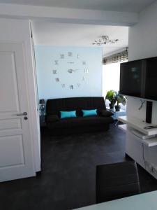 a living room with a couch and a clock on the wall at Stan in Canet-en-Roussillon