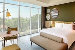 马卡萨Mercure Makassar Nexa Pettarani的带床、桌子和窗户的卧室