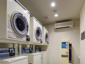 a laundry room with three washing machines on a wall at MIMARU Tokyo Nihombashi Suitengumae in Tokyo
