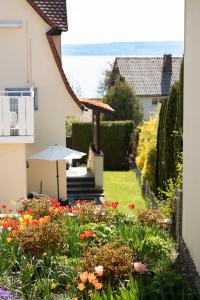 a garden with flowers and an umbrella next to a house at FeWo Meersburg in Meersburg